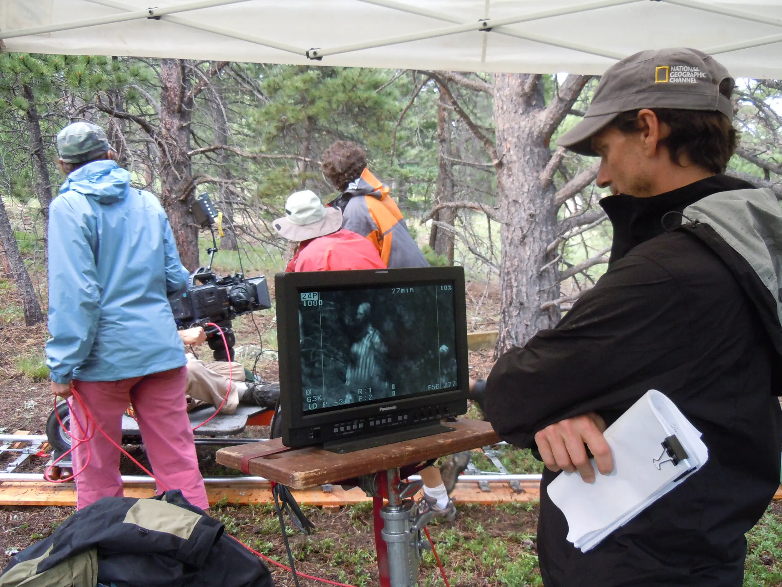 Film crew filming a recreation in a forest setting