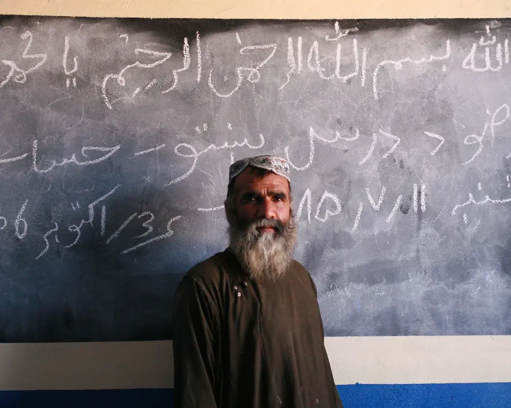 An Afghan elder in front of a chalkboard