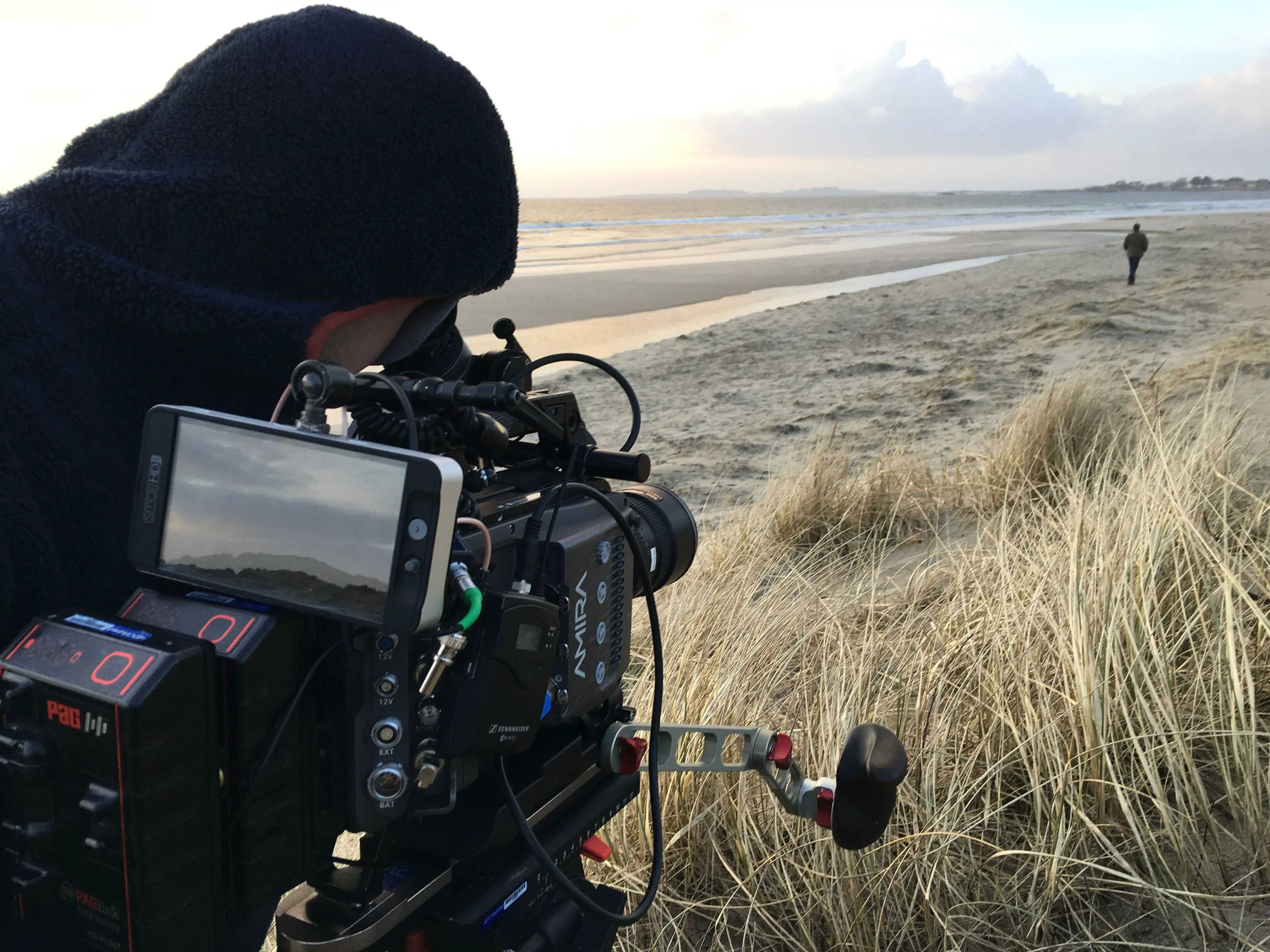 Filming on a windswept beach at golden hour