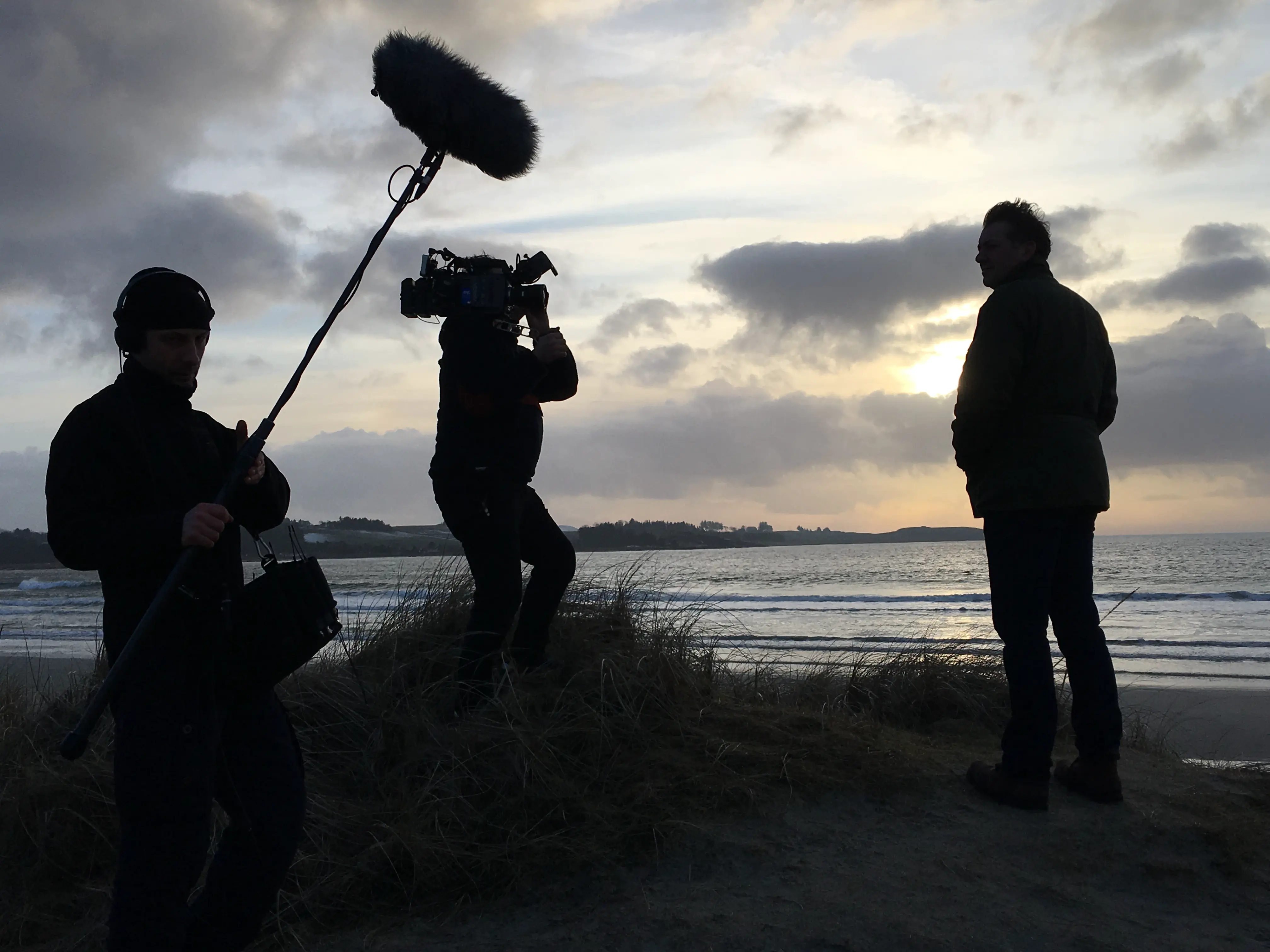 Filming an interview on the beach at sunset