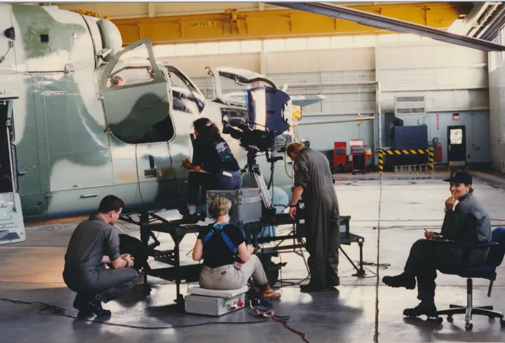 Crew filming an interview inside a helicopter hangar