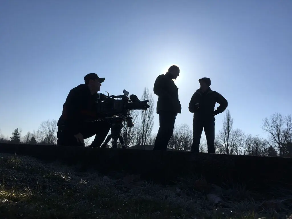 Crew silhouetted against the sky at dawn
